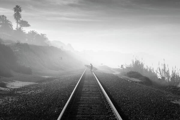 Surfer Walking Along Foggy Tracks Poster